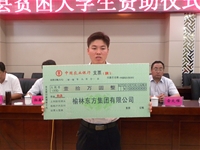 董事長賀金龍與被資助的貧困大學(xué)生合影